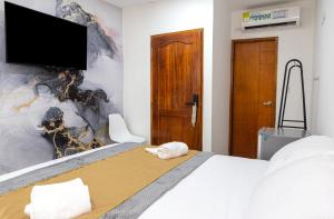- une chambre avec un lit et une télévision à écran plat dans l'établissement Markasa Hotel boutique, à Carthagène des Indes