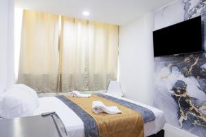 um quarto de hotel com uma cama e uma televisão de ecrã plano em Markasa Hotel boutique em Cartagena de Indias