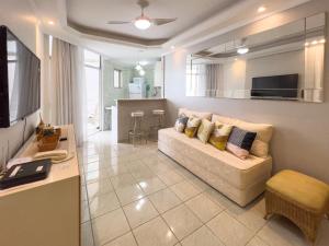 sala de estar con sofá y cocina en Apart Hotel Barra Palace com Vista Mar e Varanda B1-004, en Río de Janeiro