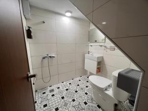 een kleine badkamer met een toilet en een douche bij Chia Lung Gold Coast Homestay in Hu-nei