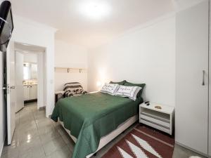 1 dormitorio con 1 cama con manta verde en Apart Hotel Barra Palace com Vista Mar e Varanda B1-004, en Río de Janeiro