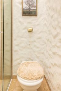 baño con aseo con una foto en la pared en La Vie en Rose, en Campos do Jordão