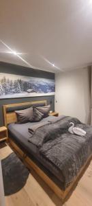 een slaapkamer met een groot bed en een schilderij aan de muur bij Appartement Krismer in Fügen