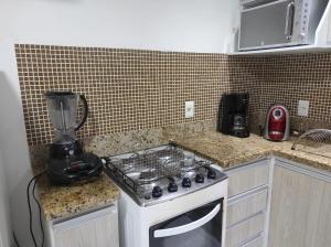 a kitchen with a stove and a blender on a counter at Lindo Flat frente praia in Vila Velha