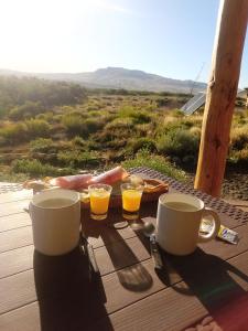 una mesa con dos tazas de zumo de naranja y tostadas en Cabañas Don Luis en Junín de los Andes