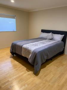 una camera con un letto in una stanza con una finestra di 3 Bedroom Holiday Apartment Peninsula Park ad Auckland