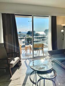 ein Wohnzimmer mit Blick auf einen Balkon in der Unterkunft Appartement bord de mer avec piscine in Saint-Laurent-du-Var