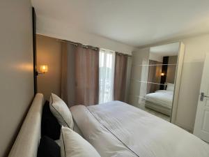ein Hotelzimmer mit einem Bett und einem Spiegel in der Unterkunft Appartement bord de mer avec piscine in Saint-Laurent-du-Var