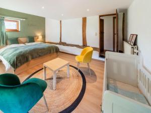 1 dormitorio con 1 cama, mesa y sillas en Magnificent holiday home in Vielsalm with bubble bath, en Vielsalm