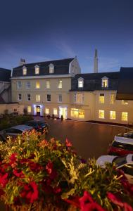 a large building with cars parked in a parking lot at Duke Of Normandie in St. Peter Port