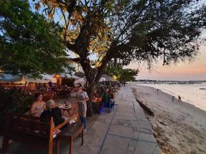 eine Gruppe von Menschen, die am Strand an Tischen sitzen in der Unterkunft Casa Agradavel Buzios - in Búzios