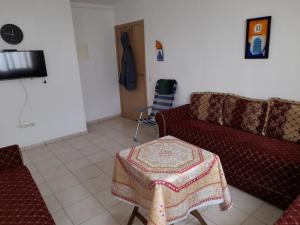 uma sala de estar com um sofá e uma mesa em Bien être Bab Sebta Joli appartement propre et proche des belles plages de la région em Fnideq