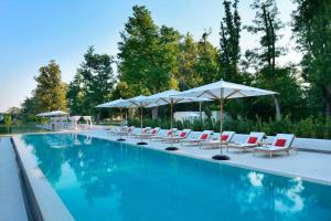 una piscina con lettini e ombrelloni di JW Marriott Venice Resort & Spa a Venezia