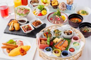a table with many different dishes of food on it at Hotel Monterey Grasmere Osaka in Osaka
