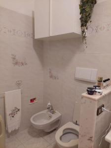 Baño blanco con aseo y lavamanos en casa da Susi, en Camaiore