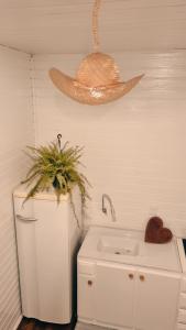 baño con lavabo y sombrero en la pared en A Casinha de Madeira en Balneário Gaivotas