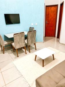 salon ze stołem, krzesłami i telewizorem w obiekcie Temporada em Miguel Pereira w mieście Miguel Pereira