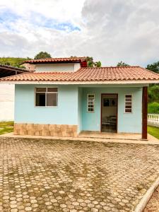 a small white house with a red roof at Temporada em Miguel Pereira in Miguel Pereira