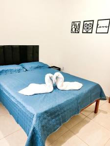 two towels are sitting on a blue bed at Temporada em Miguel Pereira in Miguel Pereira