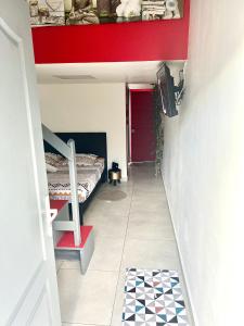 um quarto com um beliche e uma parede vermelha em Petit Chalet em Baie-Mahault