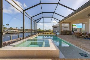 珊瑚角的住宿－Villa Antonia，一座带大型玻璃天花板的游泳池的房子
