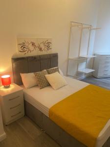 a bedroom with a large bed with a orange blanket at SEV House, Wakefield City Center in Wakefield