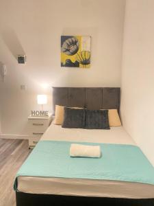 a bedroom with a large bed with a blue blanket at SEV House, Wakefield City Center in Wakefield