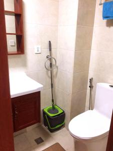 a bathroom with a toilet and a mop in the corner at Megatower Residences 3(8F-34) in Baguio
