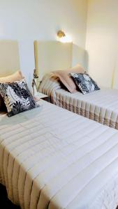 dos camas sentadas una al lado de la otra en una habitación en DEPARTAMENTO San Jorge en Mendoza