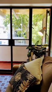 sala de estar con sofá y algunas ventanas en DEPARTAMENTO San Jorge en Mendoza