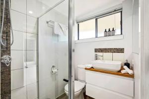 a bathroom with a shower and a toilet and a sink at Charming Coastal Studio 900m to the Beach in Kawana Waters