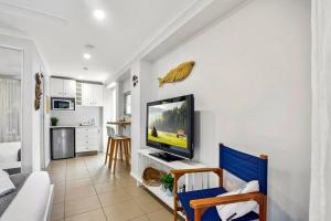 a living room with a flat screen tv on a wall at Charming Coastal Studio 900m to the Beach in Kawana Waters