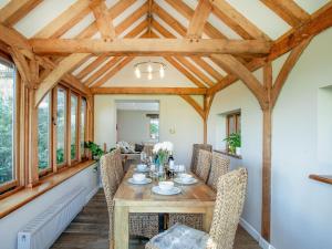 South Pusehill Cottage في وستوارد هو: غرفة طعام مع طاولة وكراسي خشبية