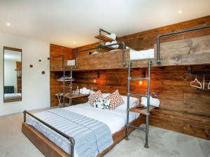 a bedroom with bunk beds and a wooden wall at South Pusehill Cottage in Westward Ho