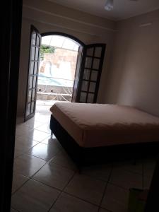 een slaapkamer met een bed en een open deur bij Chácara de luxo aconchegante no centro de Socorro! in Socorro