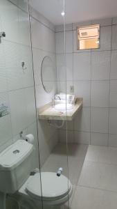 a bathroom with a shower with a toilet and a sink at Pousada Mirante do Cunhaú in Barra do Cunhau