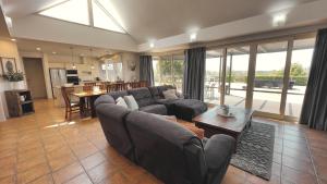 a living room with a couch and a table at Grapevines Boutique Accommodation in Pokolbin