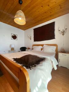 a bedroom with a large bed with a wooden ceiling at Bohemian Chalet in Buşteni