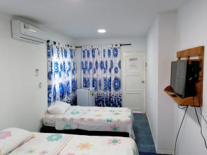a small room with two beds and a tv at Posada Salt Creek in Providencia