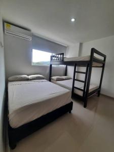 1 dormitorio con 2 literas y ventana en Apartamento Recreativo en Santa Fe de Antioquia