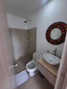 y baño con aseo, lavabo y espejo. en Apartamento Recreativo en Santa Fe de Antioquia