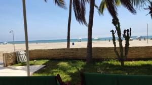 uma vista para a praia a partir de um resort com palmeiras em Hotel House Hoskins Talara- con AIRE ACONDICIONADO, uso de cocina em Talara