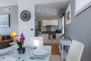 cocina y sala de estar con mesa blanca y sillas en SERRENDY 2-bedroom- with terrace & pool, en Cannes