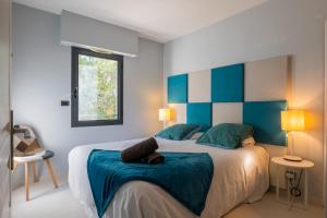1 dormitorio con 1 cama grande de color azul y blanco en SERRENDY 2-bedroom- with terrace & pool, en Cannes