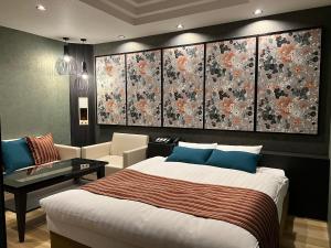 a bedroom with a large bed and a living room at Hotel Park Hill in Sasebo