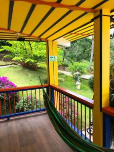 Belén de Umbría的住宿－Hotel Hacienda San Isidro，门廊上的吊床,享有花园景色