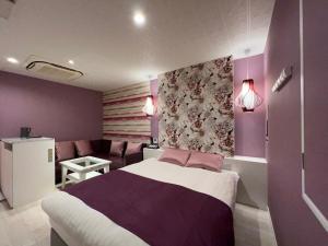 a bedroom with purple walls and a bed and a couch at Hotel Park Hill in Sasebo