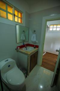 a bathroom with a toilet and a sink at Hotel Hacienda San Isidro in Belén de Umbría