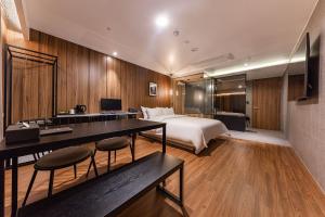 a hotel room with a bed and a desk with chairs at Brown Dot Hotel Seosan in Seosan