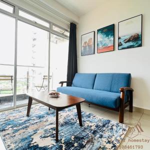 uma sala de estar com um sofá azul e uma mesa de centro em KULAI IOI MALL D'Putra Suites Near JPO Senai Airport 